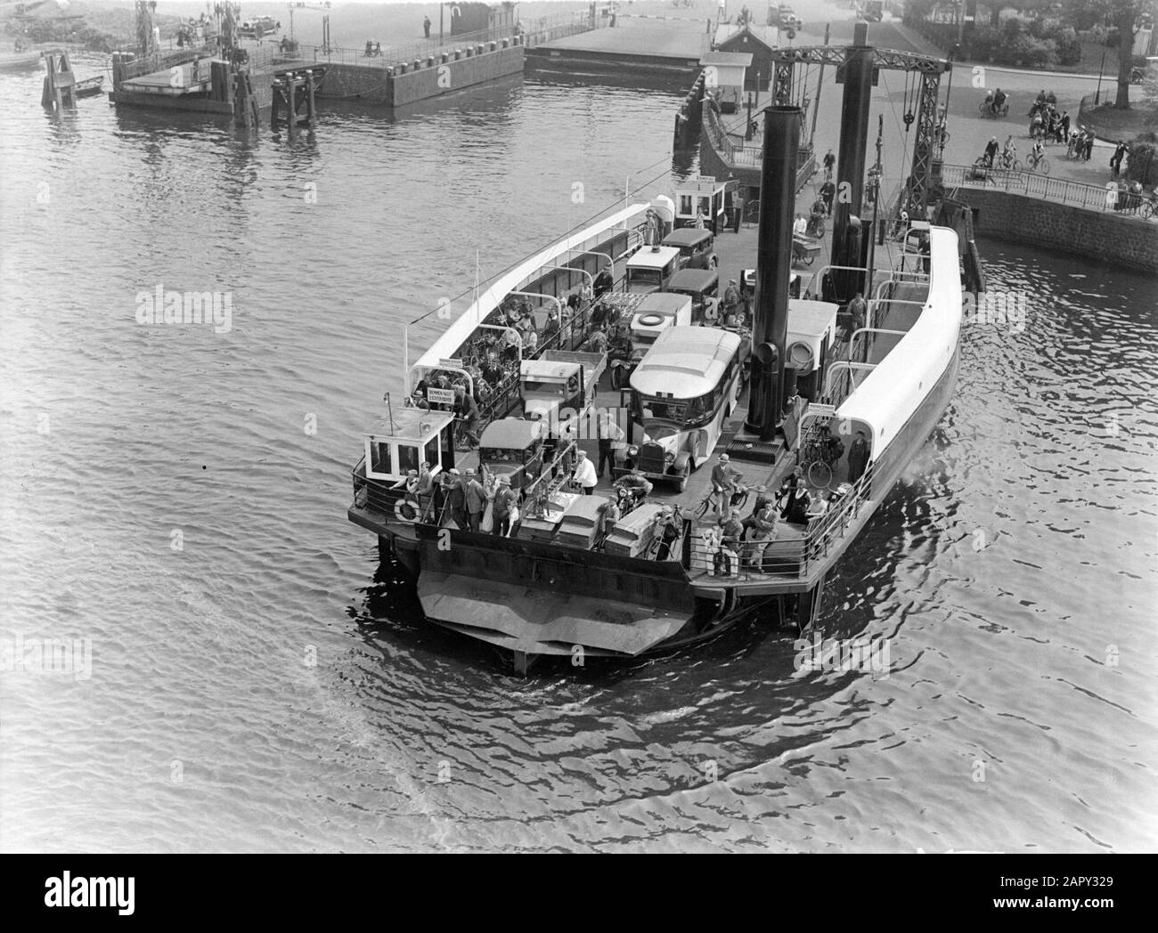 Viaggio in mare con MS Johan van Oldenbarnevelt in Norvegia Vista dai ms Johan van Oldenbarnevelt quando si lascia il IJmuider serrature: Il Velserpont sul canale del Mare del Nord con camion, auto, ciclisti e pedoni Data: 1933 Località: IJmuiden, Noord-Holland, Norvegia Parole Chiave: automobili, crociere, navi da crociera, ciclisti, chiuse, turismo, traghetti, traffico, pedoni, camion Foto Stock