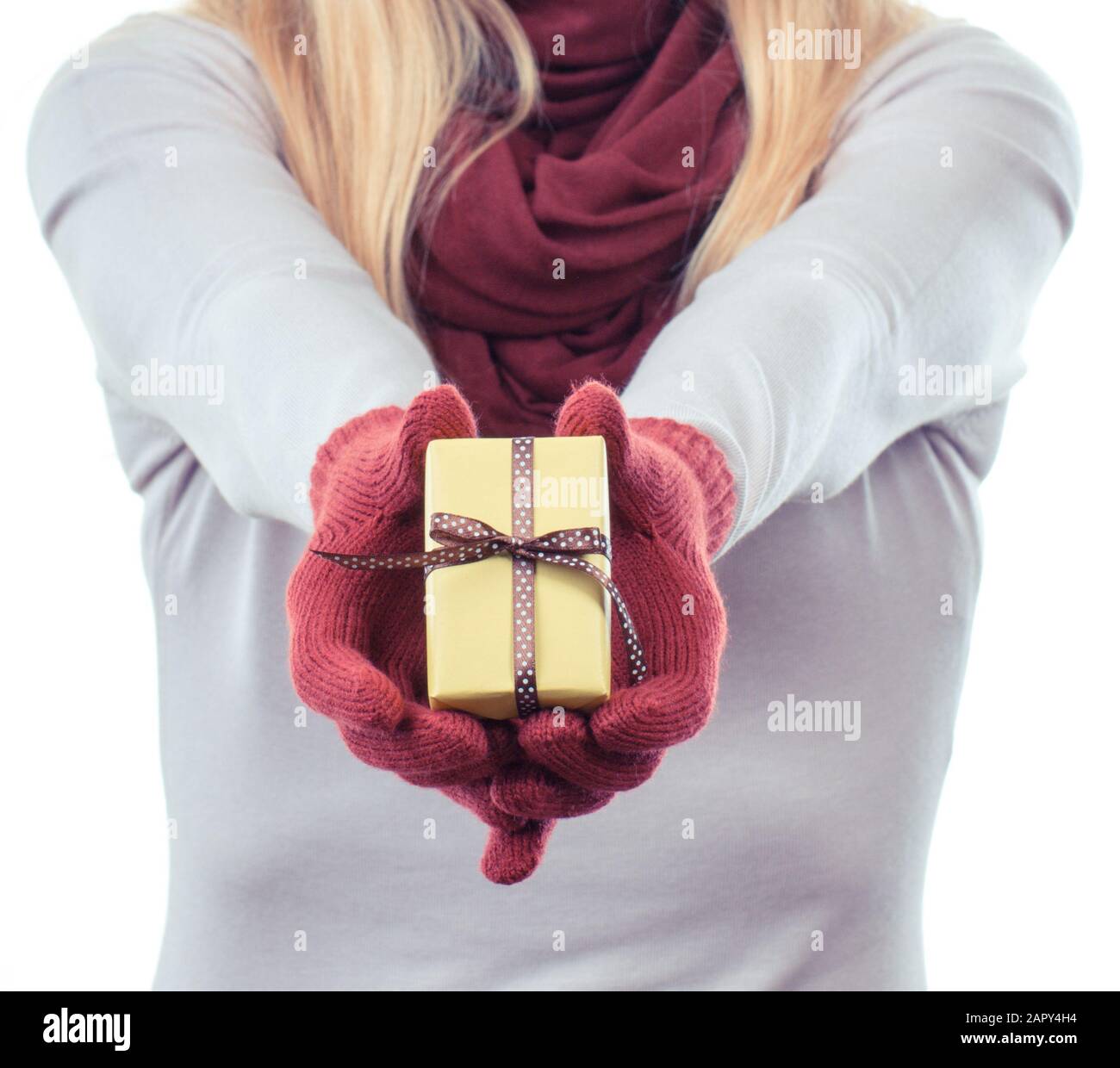 La mano della donna nei guanti di lana avvolto di contenimento regalo per Natale, Valentino, compleanno o altra celebrazione Foto Stock