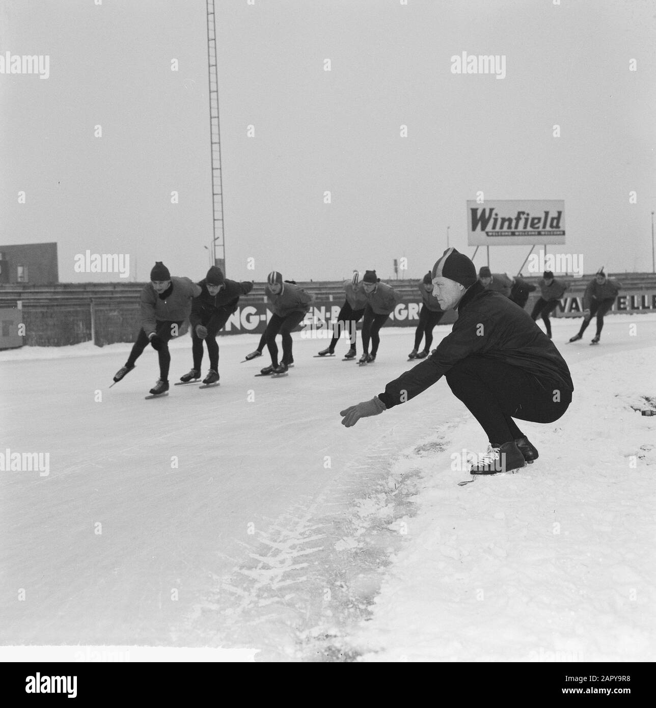 Formazione olandese Kernploeg sulla pista di pattinaggio Deventer. Il Trainer Lamberts fornisce indicazioni per i conducenti di Van der Gript, Kieviet, Heyst, Liebrechts, Nottet, Renes Data: 12 dicembre 1963 Località: Deventer, Overijssel Parole Chiave: Indizi, pattinaggio, sport, trainer Nome personale: Nottet, Peter Foto Stock