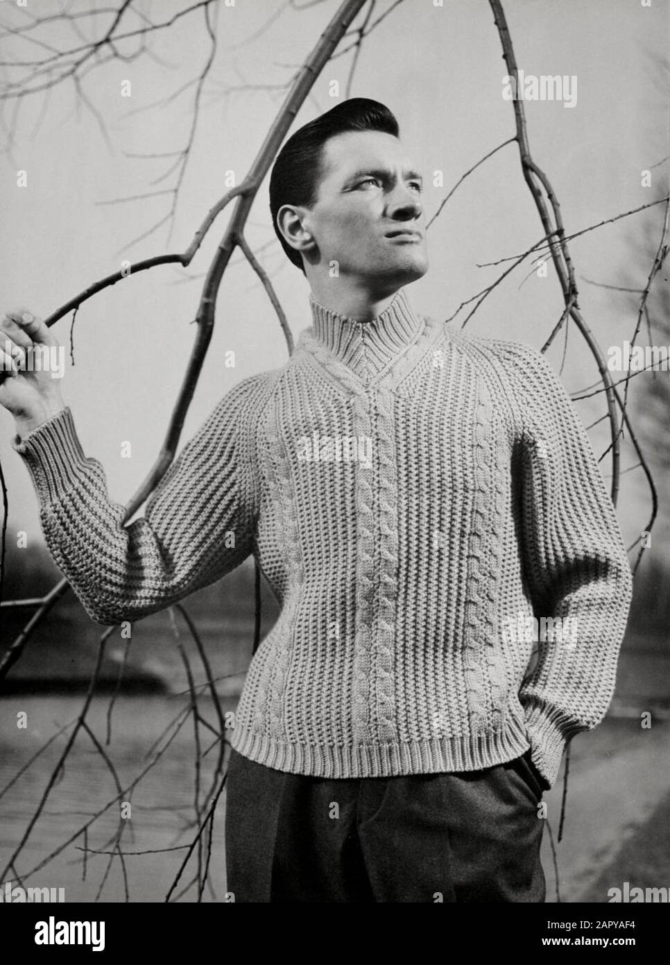 Moda casalinga, moda maschile, maglieria. Uomo in maglia con collo a V con maniche raglan a coste con cavi. Paesi Bassi [1960-1969]. Foto Stock
