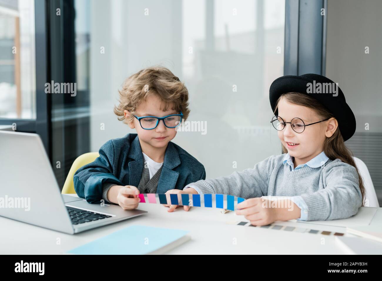 Due amiciolkids in casualwear scegliendo il colore dal campione dalla scrivania Foto Stock