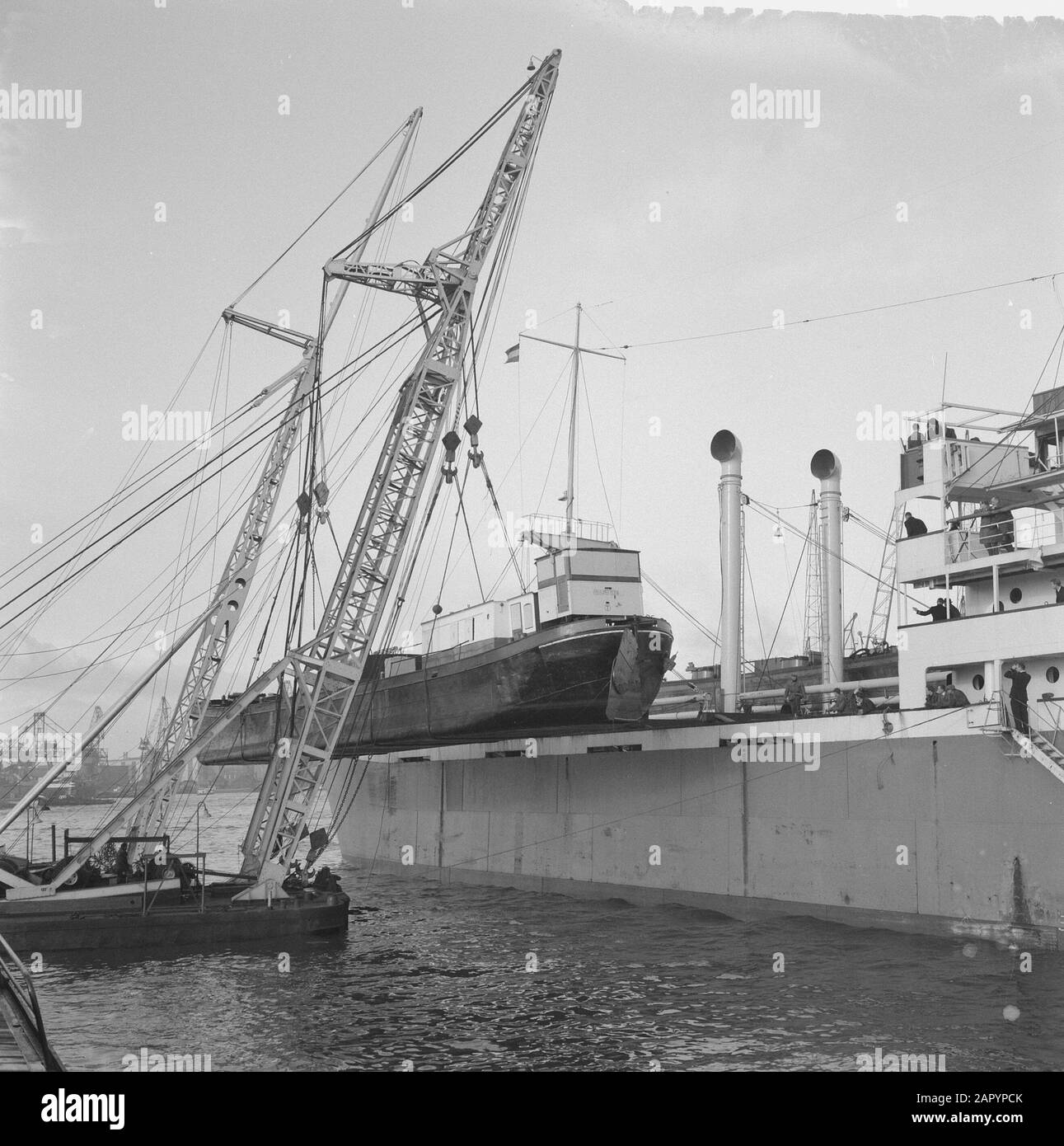 Due tanklisters sono hoisted a bordo da due capre galleggianti a bordo della nave di carico Lohoja Palm a Rotterdam Data: 12 gennaio 1961 Località: Rotterdam, Zuid-Holland Parole Chiave: Porti, spedizione : Behrens, Herbert/Anefo, Foto Stock