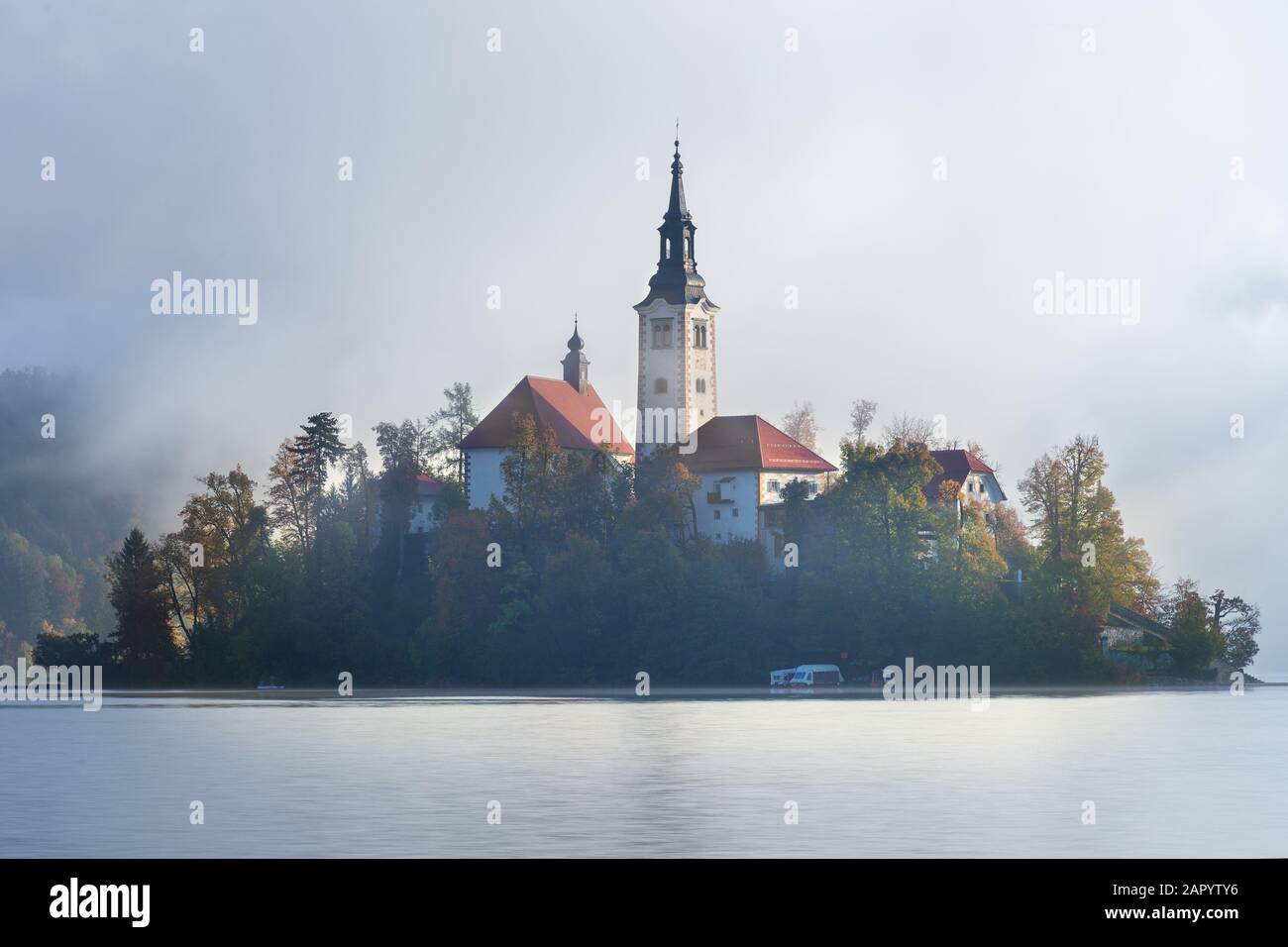 Il pellegrinaggio Chiesa dell'Assunzione di Maria sul lago di Bled in una nebbiosa mattinata torbida Foto Stock