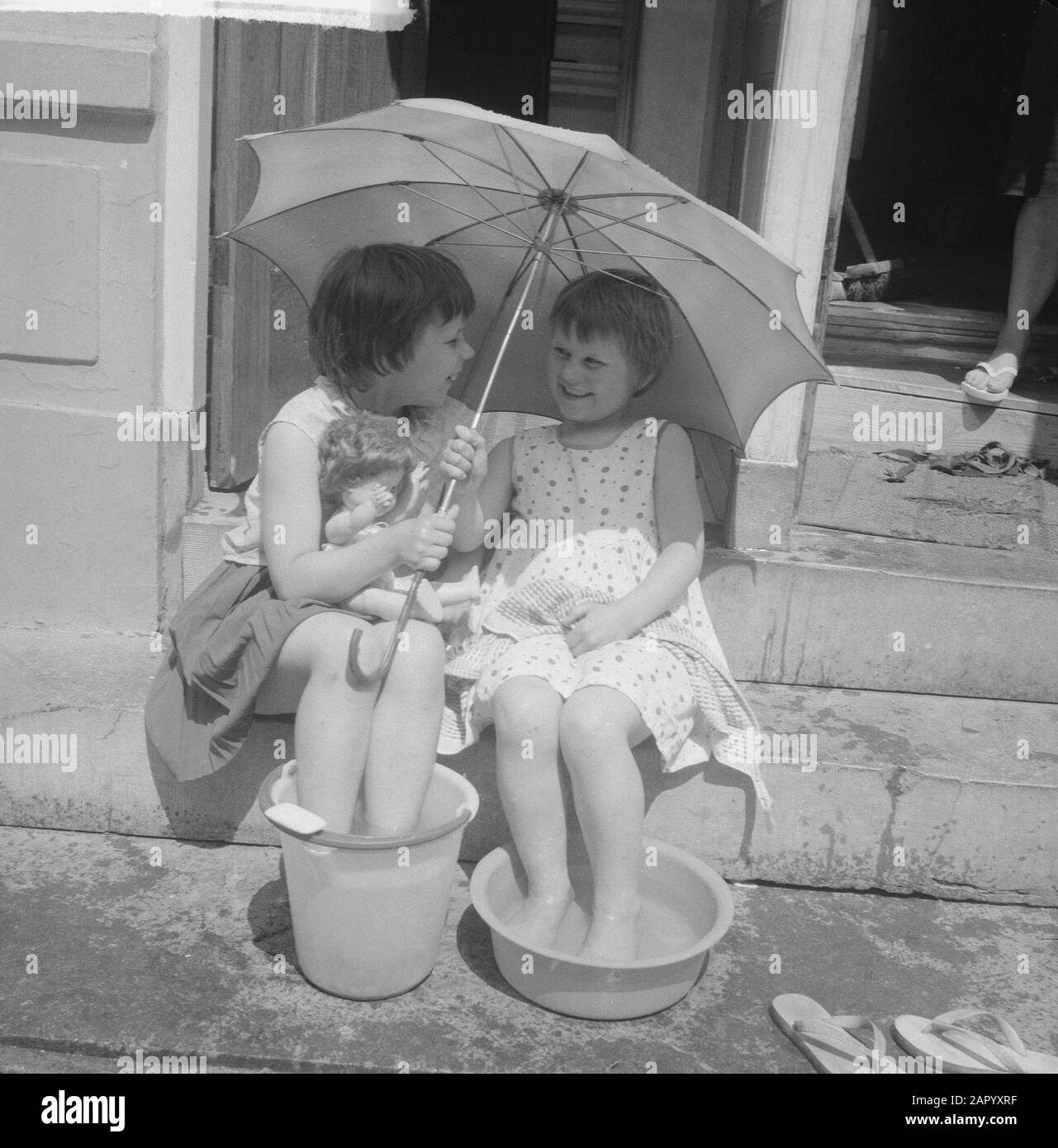 Calore ad Amsterdam. Bambini in Kerkstraat in a teil Water Data: 30 Giugno 1961 luogo: Amsterdam, Noord-Holland Parole Chiave: Bambini, ombrelloni, acqua Foto Stock