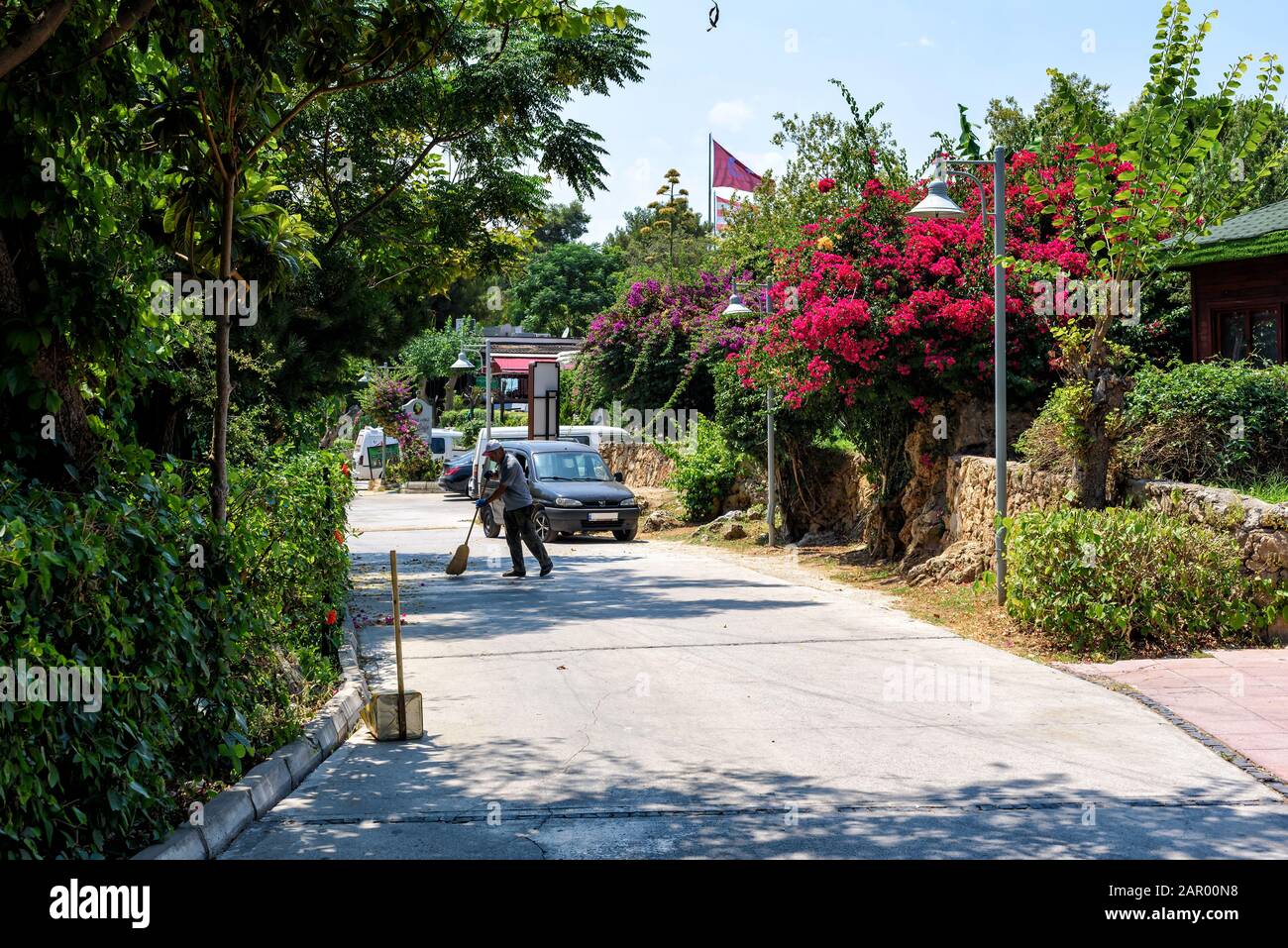 Antalya, Turchia - 26 luglio 2019: Street janitor sweep foglie secche sulla strada in una giornata estiva ad Antalya Foto Stock