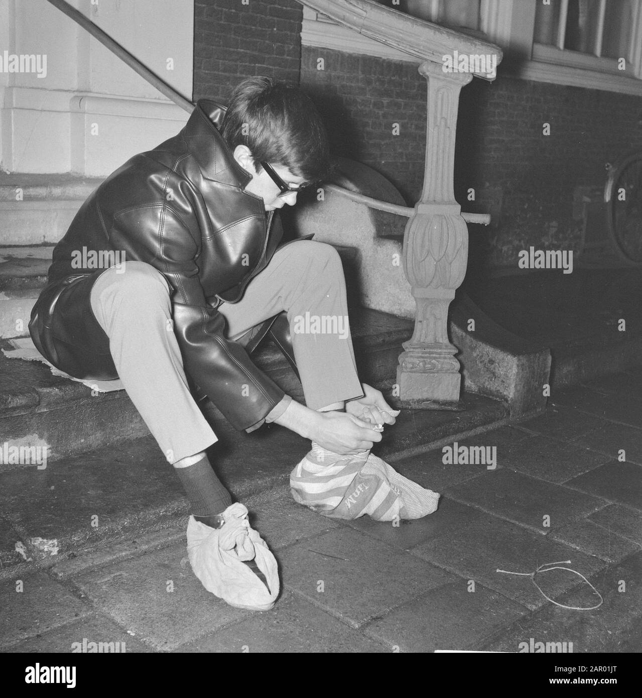 Ragazzo fa panni intorno alle sue scarpe nella data senza maniche: 18 dicembre 1961 Parole Chiave: IJZEL, RAGAZZO, SCARPE Foto Stock