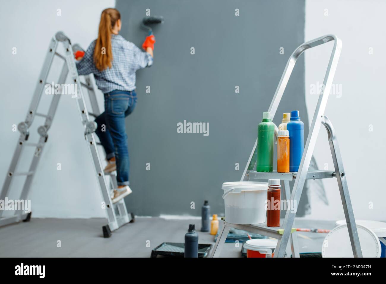 Donna pittore casa dipinge pareti interne Foto Stock