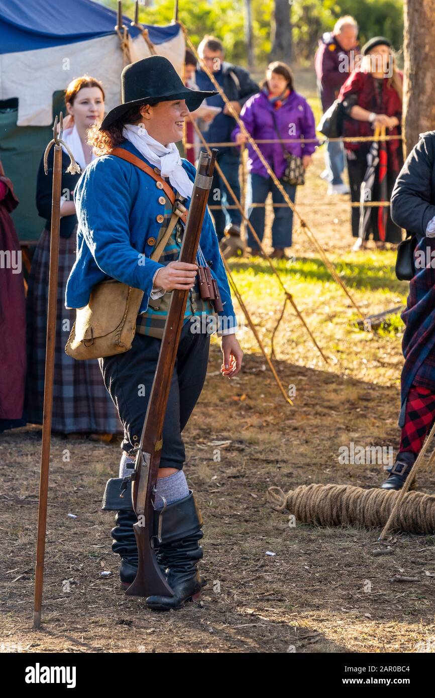 Membro del gruppo Scottish Living History nel vestito tradizionale dimostra il caricamento e la spara del fucile Flintlock al Glen Innes Celtic Festival NSW Foto Stock