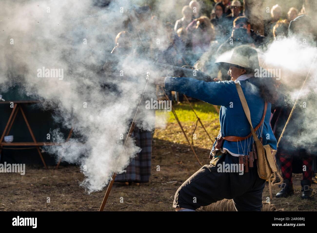 Membro del gruppo Scottish Living History nel vestito tradizionale dimostra il caricamento e la spara del fucile Flintlock al Glen Innes Celtic Festival NSW Foto Stock