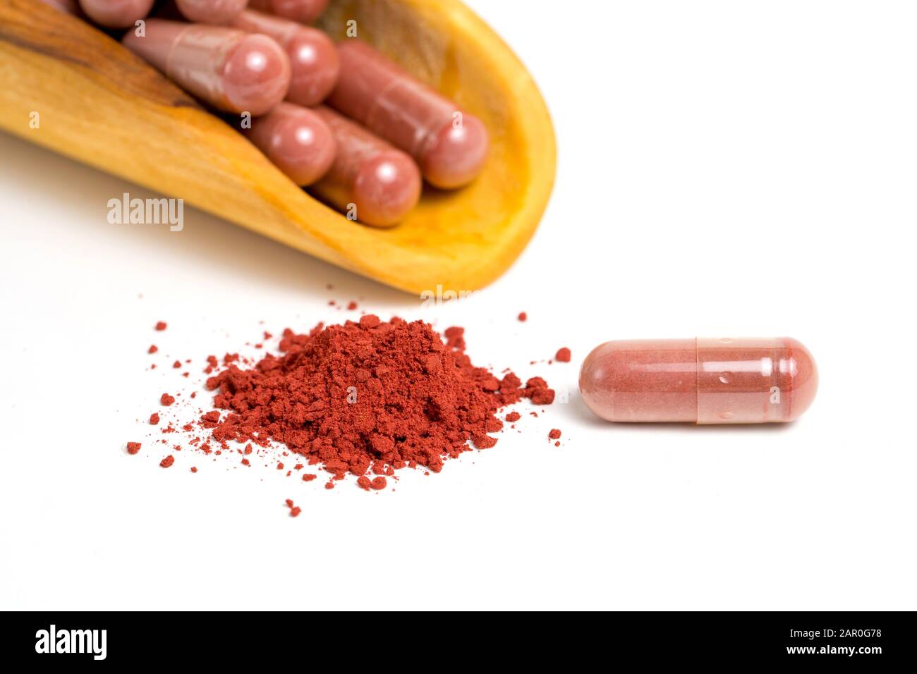 Riso di lievito rosso o angkak o polvere di riso kojic e capsula supplementare su sfondo bianco isolato Foto Stock