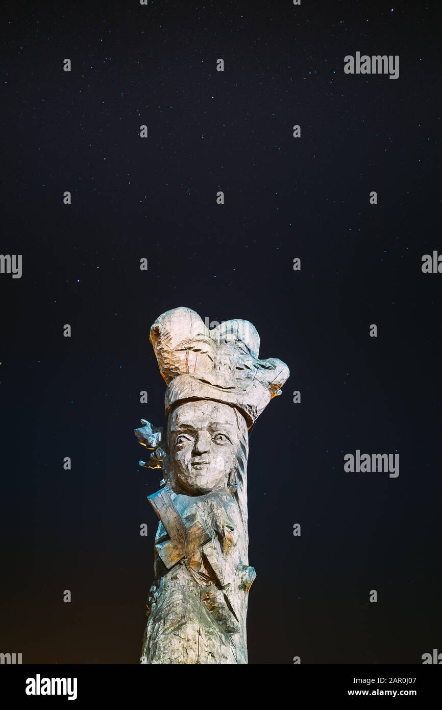 Ruzhany, regione di Brest, Bielorussia. Cielo stellato sopra di sculture in legno figure bielorussa personaggi storici in autunno la notte. Punto di riferimento sotto la notte S Foto Stock