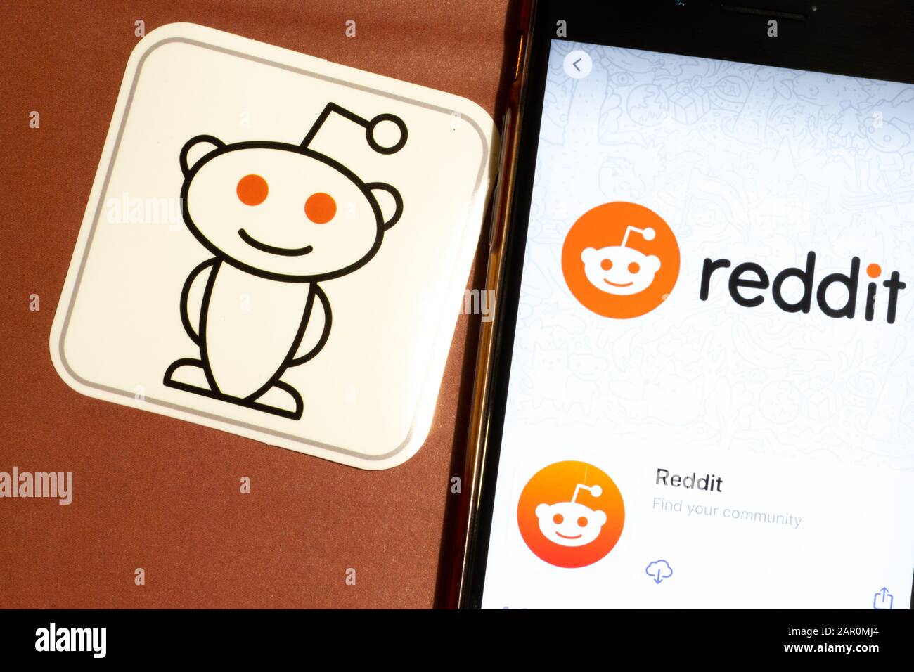 Los Angeles, California, Stati Uniti - 22 gennaio 2020: Logo Reddit app e telefono con icona primo piano su sfondo marrone, Editoriale Illustrativo Foto Stock