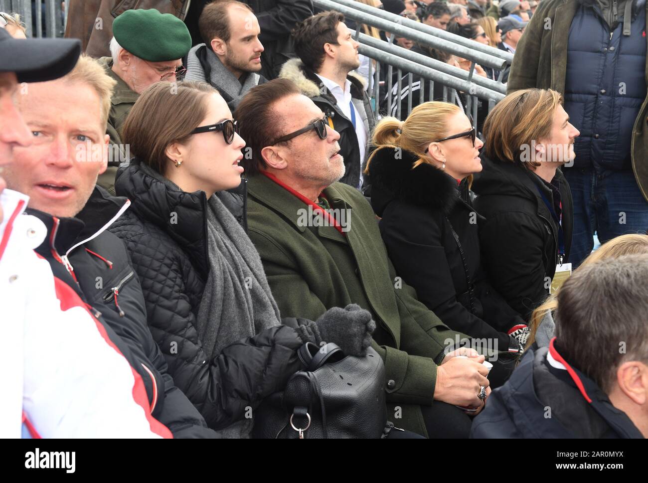 25 Gennaio 2020, Austria, Kitzbühel: L'attore Arnold Schwarzenegger (m), insieme alla figlia Christina (2nd da sinistra), la sua ragazza Heather Milligan (2nd da destra) e suo nipote, Patrick Knapp-Schwarzenegger, (l) sulla tribuna VIP nella zona finale della gara di Hahnenkamm, guardando la discesa degli uomini sulla Streif. Foto: Felix Hörhager/dpa - ATTENZIONE: Solo per uso editoriale in relazione alla segnalazione attuale e solo con la menzione completa del credito di cui sopra. Nessuna pubblicità. Foto Stock