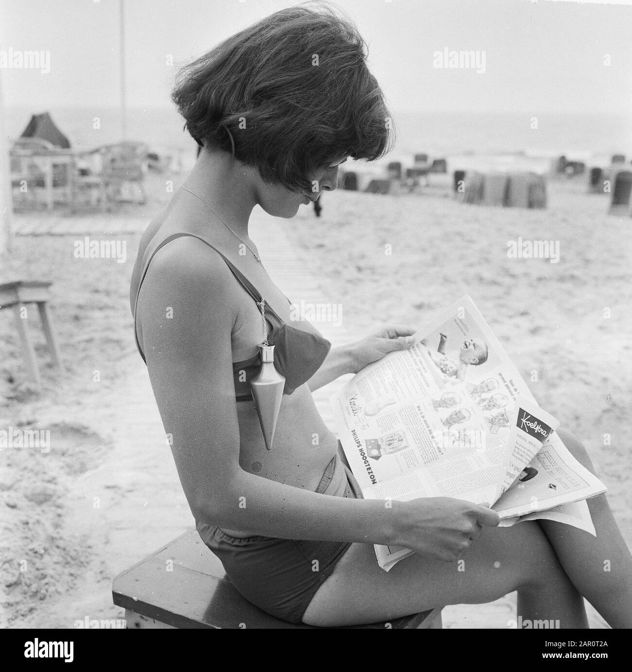 Strandfashion 1964, giovane donna indossa il nuovo pizzico nel campo dell'olio solare Data: 20 maggio 1964 Parole Chiave: Beachfashion, Signore Foto Stock