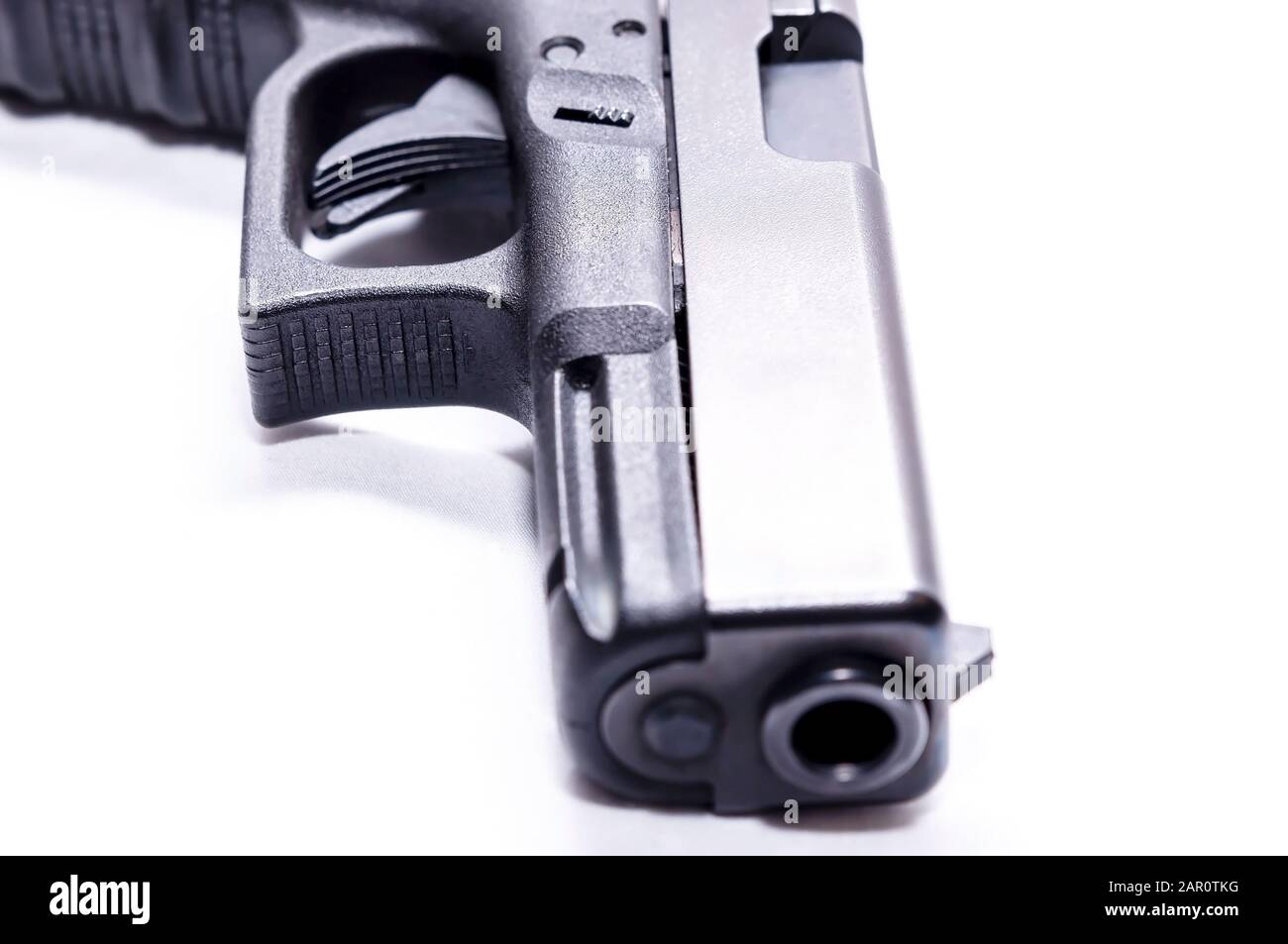 Il muso di una pistola semi-automatica nera 9mm con sfondo bianco Foto Stock