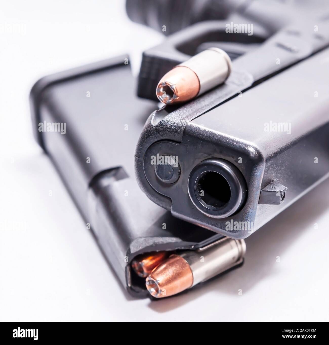 Una pistola semi-automatica 9mm nera con caricatore a pistola caricato con un unico proiettile a punta cava 9mm su sfondo bianco Foto Stock