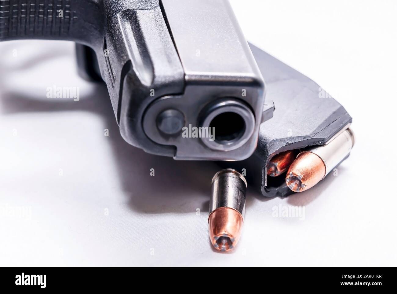 Una pistola semi-automatica 9mm nera con caricatore a pistola caricato con un unico proiettile a punta cava 9mm su sfondo bianco Foto Stock