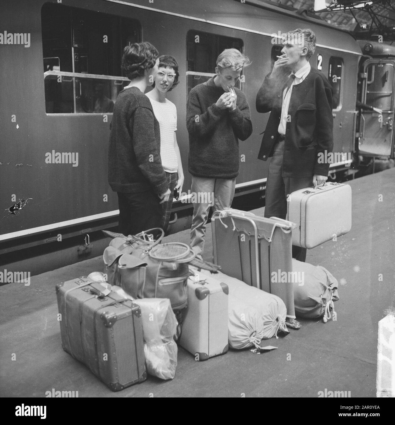 Vacanza iniziata, persone con valigie alla Stazione Centrale di Amsterdam Data: 17 Luglio 1964 Località: Amsterdam, Noord-Holland Parole Chiave: Valigie, passeggeri, treni Foto Stock