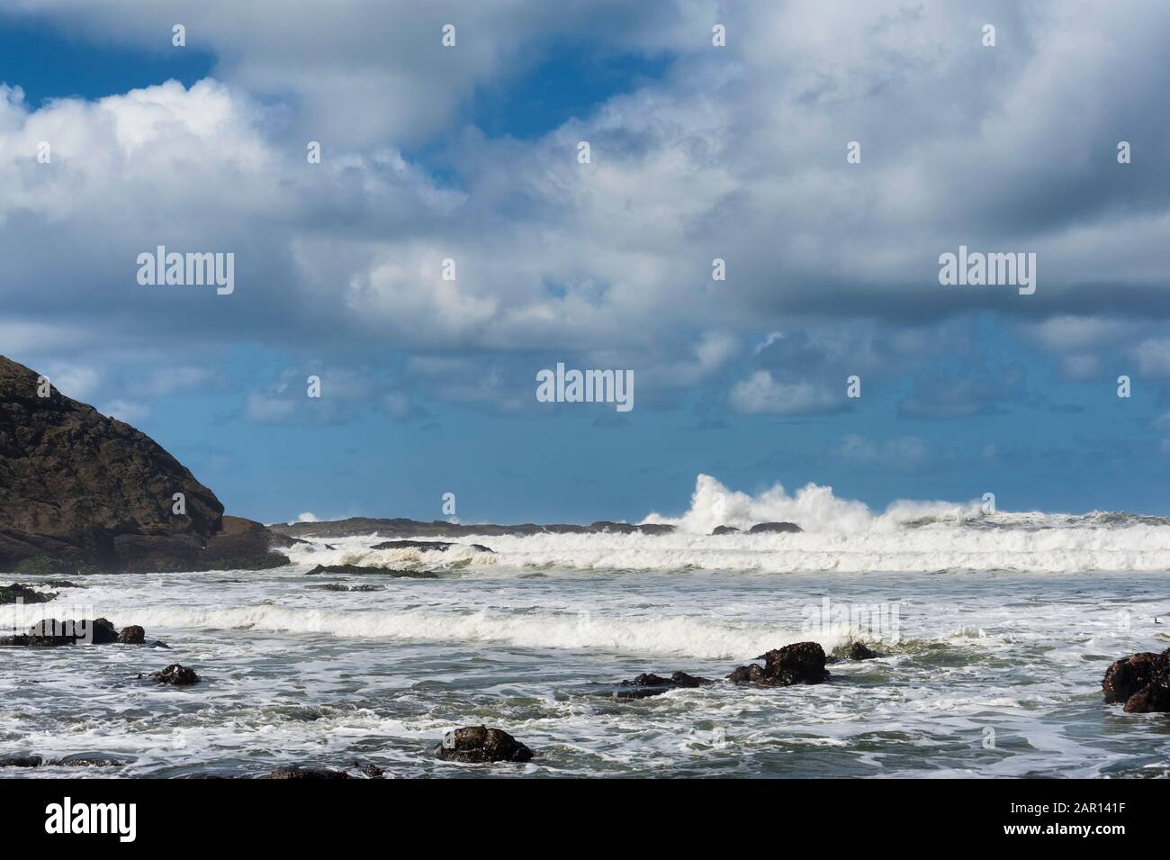 Vista sulla spiaggia costiera dell'Oregon all'orizzonte mentre le onde arrivano a riva. Foto Stock