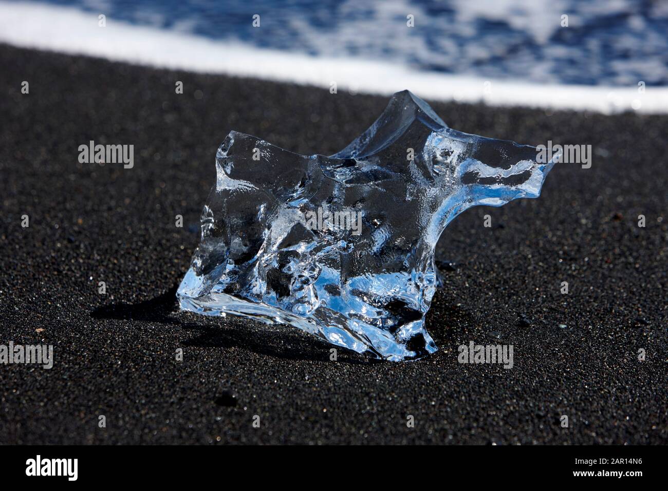 Frammento ghiacciato di iceberg lavato sulla sabbia nera della spiaggia di Breidamerkursandur jokulsarlon islanda Foto Stock