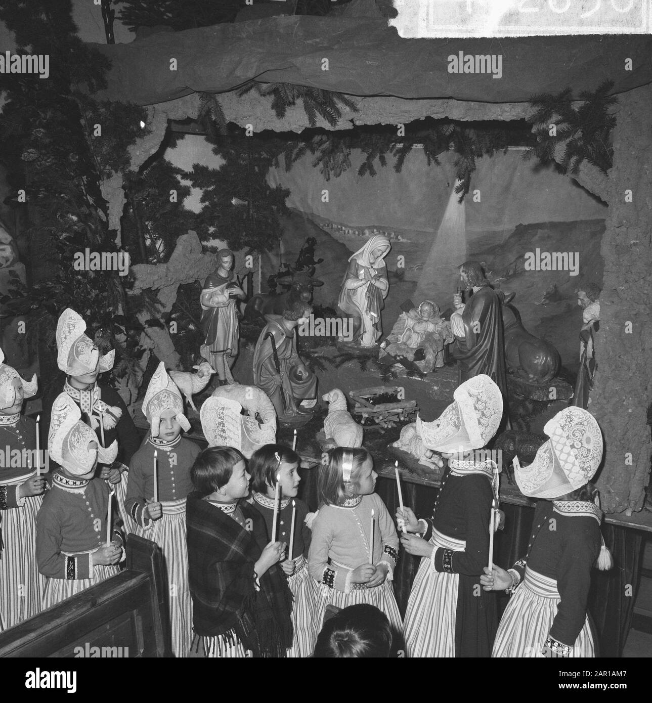 Natale a Volendam, bambini nel Vincentiuskerk guardando presepe di Natale Data: 21 Dicembre 1964 Località: Noord-Holland, Volendam Parole Chiave: Natale, bambini, costume Foto Stock