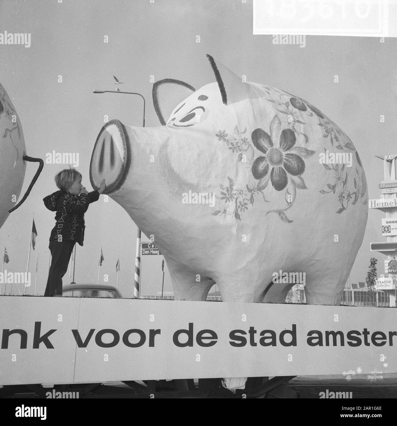 World Savings Day Action. Due gigantesche banche piccanti su un rimorchio con il testo: Banca di risparmio per la Città di Amsterdam Bambino guardando da vicino una delle giganti banche piggy Data: 25 ottobre 1965 Località: Amsterdam, Noord-Holland Parole Chiave: Banche, bambini, parate, risparmio Foto Stock
