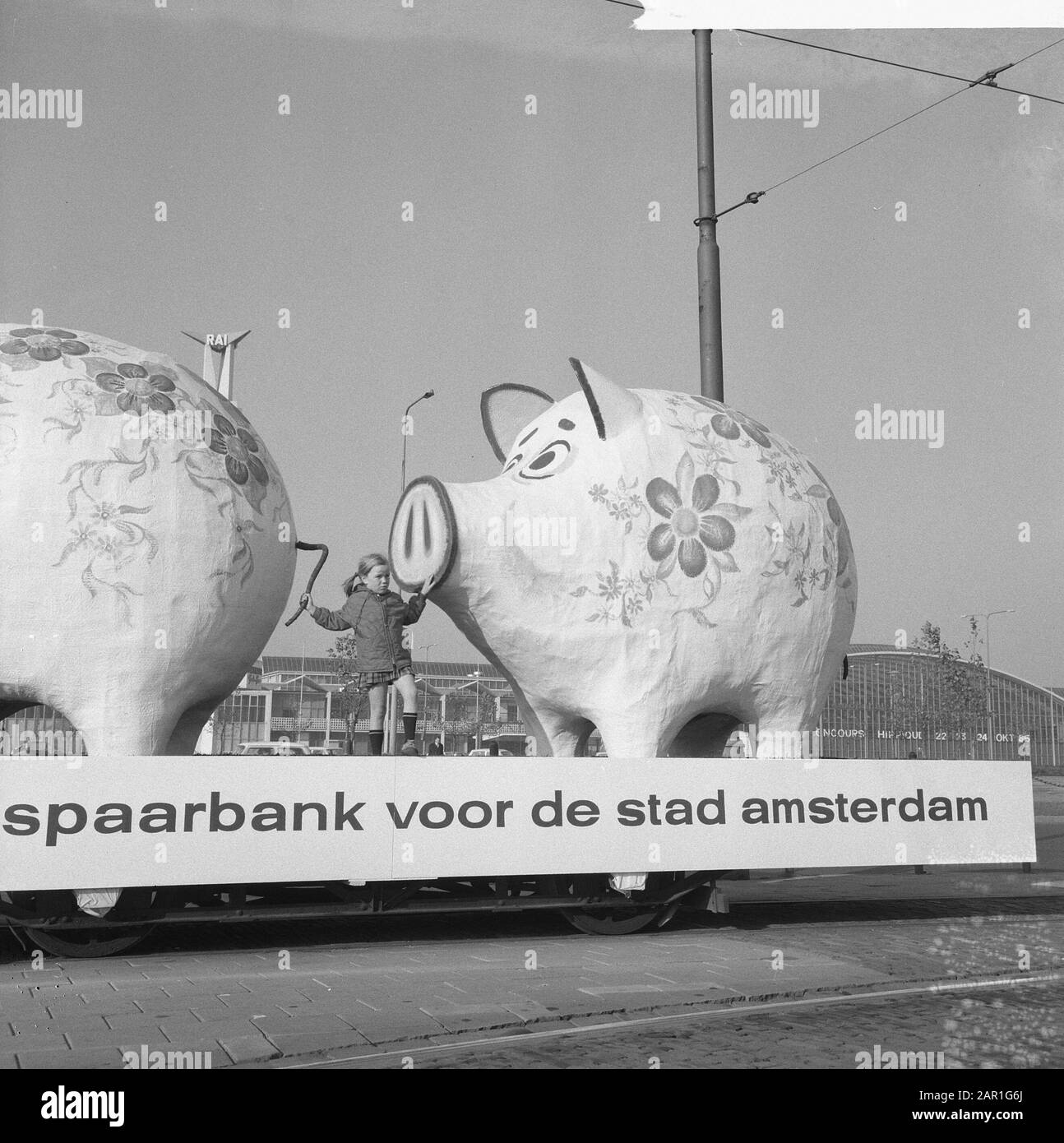 World Savings Day Action. Due gigantesche banche piccanti su rimorchio con il testo: Banca di risparmio per la città di Amsterdam Bambino in piedi accanto alla banca piggy Data: 25 ottobre 1965 Località: Amsterdam, Noord-Holland Parole Chiave: Banche, bambini, parate, risparmio Foto Stock