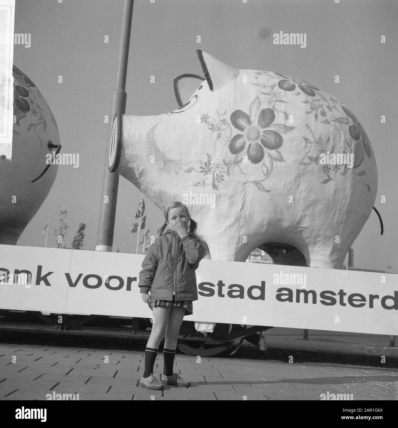 World Savings Day Action. Due gigantesche banche piccanti su un rimorchio con il testo: Banca di risparmio per la città di Amsterdam Bambino in piedi di fronte a una delle gigantesche banche piccanti su un rimorchio Data: 25 ottobre 1965 Località: Amsterdam, Noord-Holland Parole Chiave: Banche, bambini, parate, risparmio Foto Stock