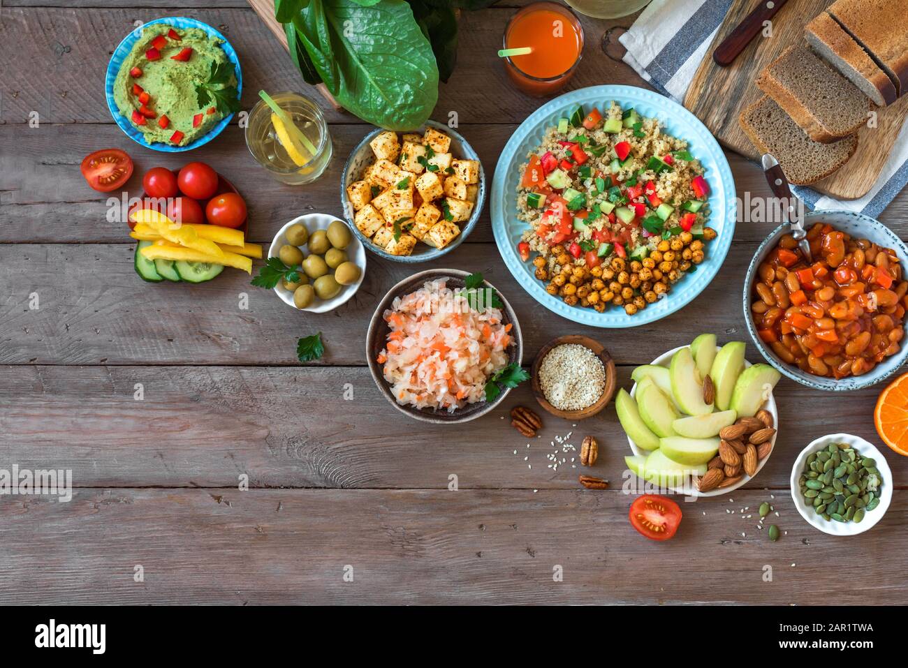 Sano tavolo da pranzo vegano, set di sani piatti vegetariani vegani - insalata di quinoa e ceci, tofu fritto, hummus dip, frutta, verdure, Foto Stock