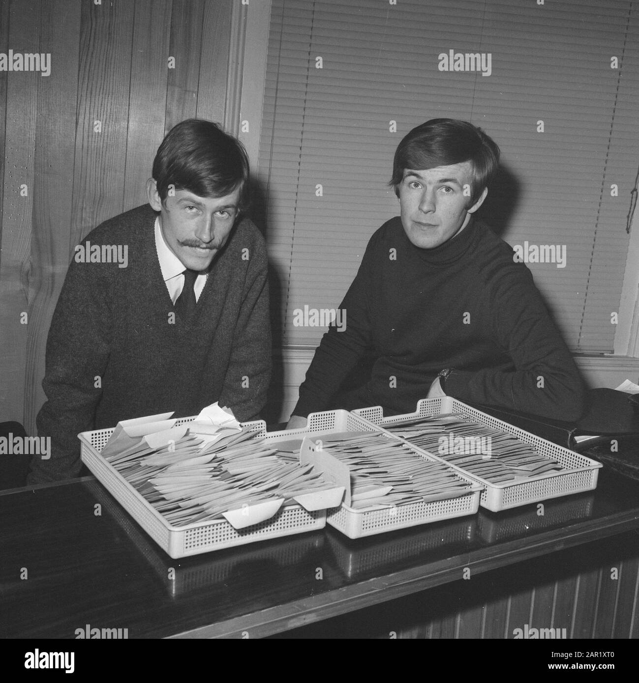 Rapina allo studente Werkbureau Amsterdam sinistra R. Soeting che era presente, destra G. Herts con di fronte a loro gli stipendi Data: 8 novembre 1968 Località: Amsterdam, Noord-Holland Parole Chiave: Studenti, rapine, stipendi Nome personale: G. Herts, Soeting, R. Foto Stock