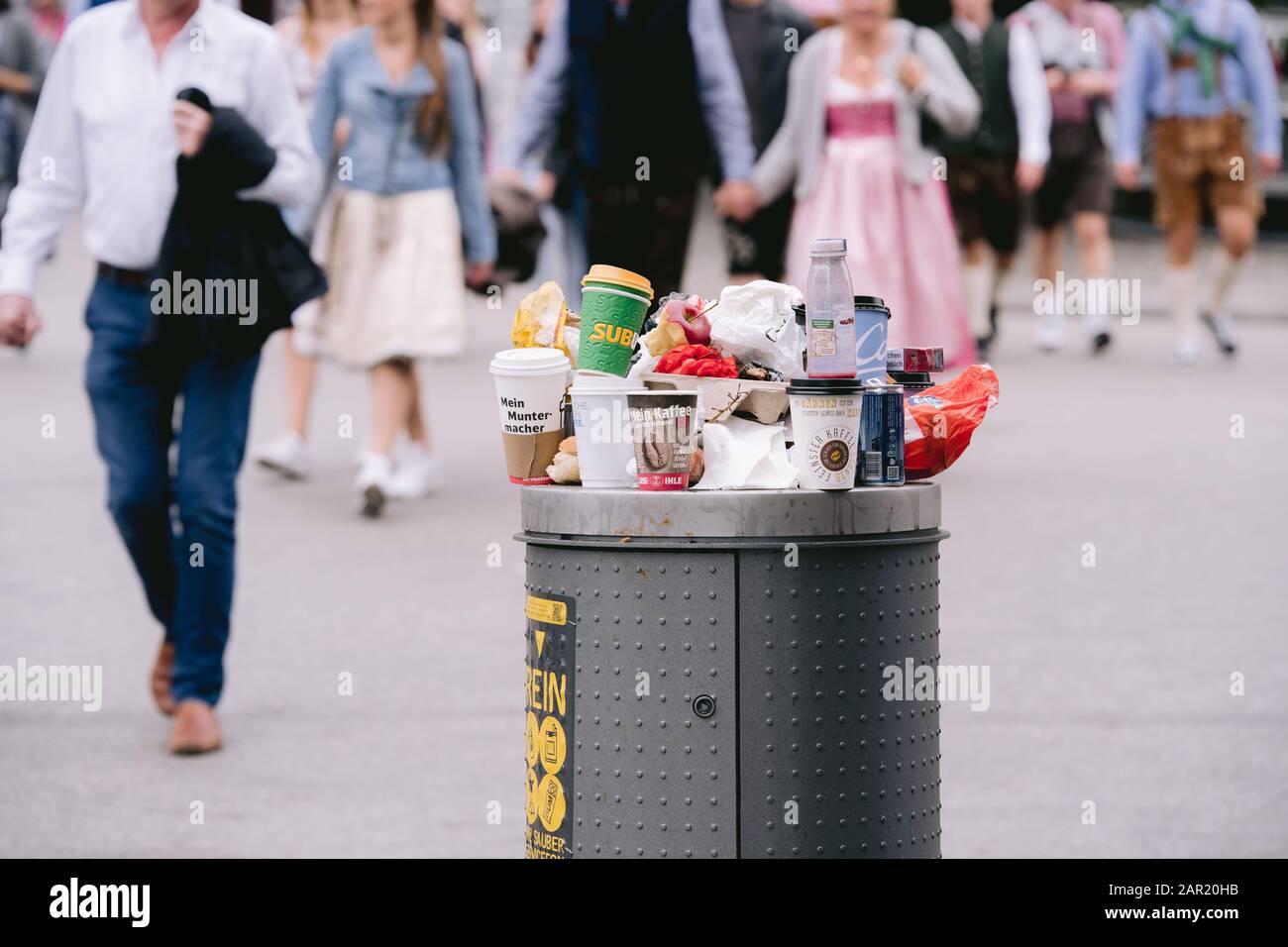 Monaco di Baviera, GERMANIA - 22 settembre 2019: Traboccante immondizia può sprecare bidone al festival mondiale Oktoberfest a monaco con persone sfocate in background Wari Foto Stock