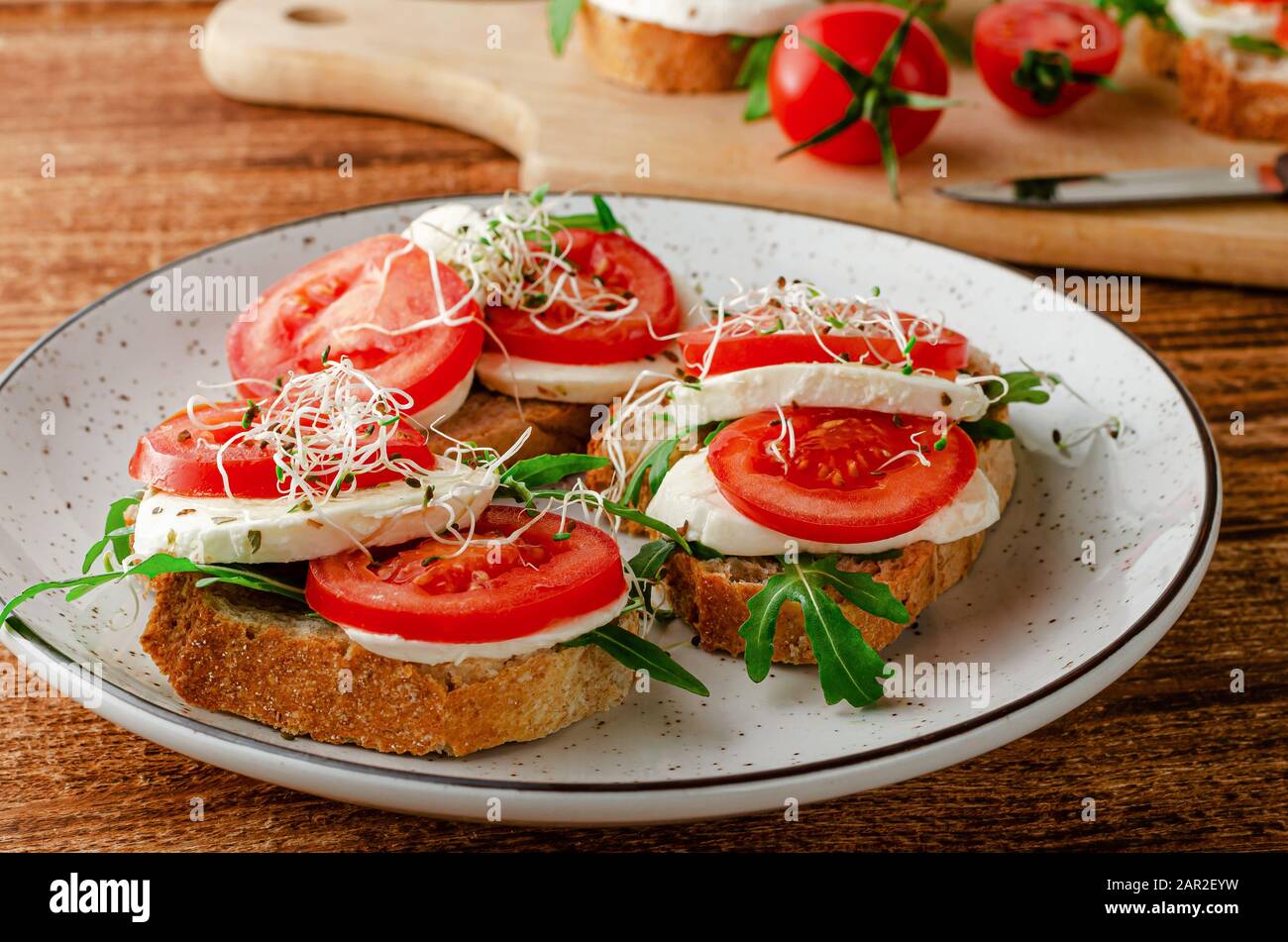 Sandwich aperti con mozzarella fresca, pomodori e rucola. Concetto di cibo italiano Foto Stock