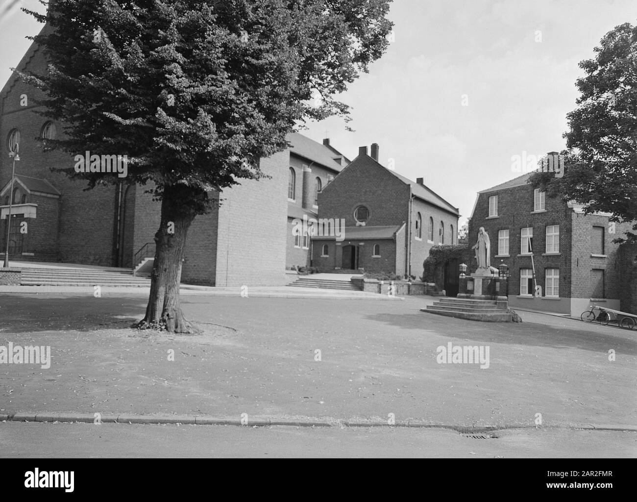 Chiesa di San Pietro a Baarlo, con la statua del Sacro Cuore nella piazza vicino alla chiesa. Data: Agosto 1958 Luogo: Baarlo Parole Chiave: Chiese, Piazze, Statue Nome Personale: H Heart Image Institution Name: Roman Catholic Church Foto Stock