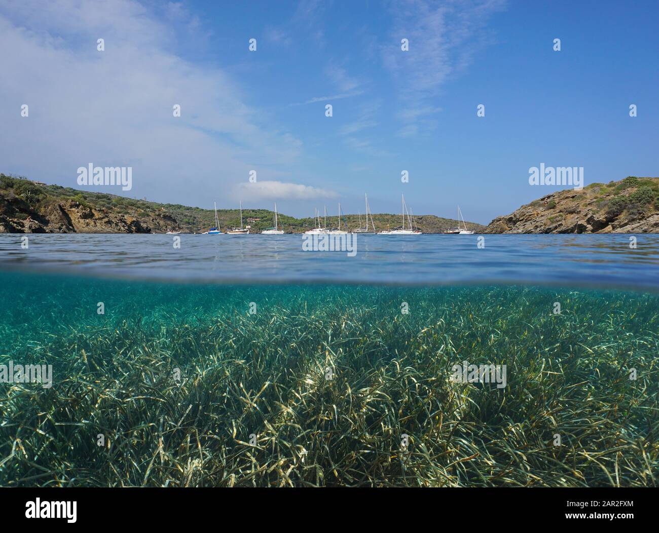 Litorale mediterraneo con barche a vela ormeggiate in una baia e mare sott'acqua, vista su e sotto superficie d'acqua, Spagna, Costa Brava Foto Stock