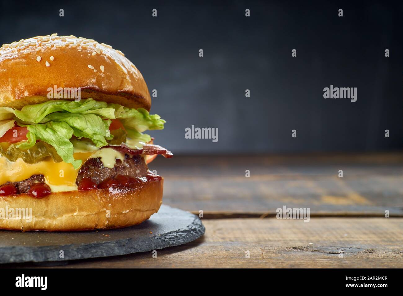 Hamburger fresco su sfondo di legno scuro. Spazio di copia Foto Stock