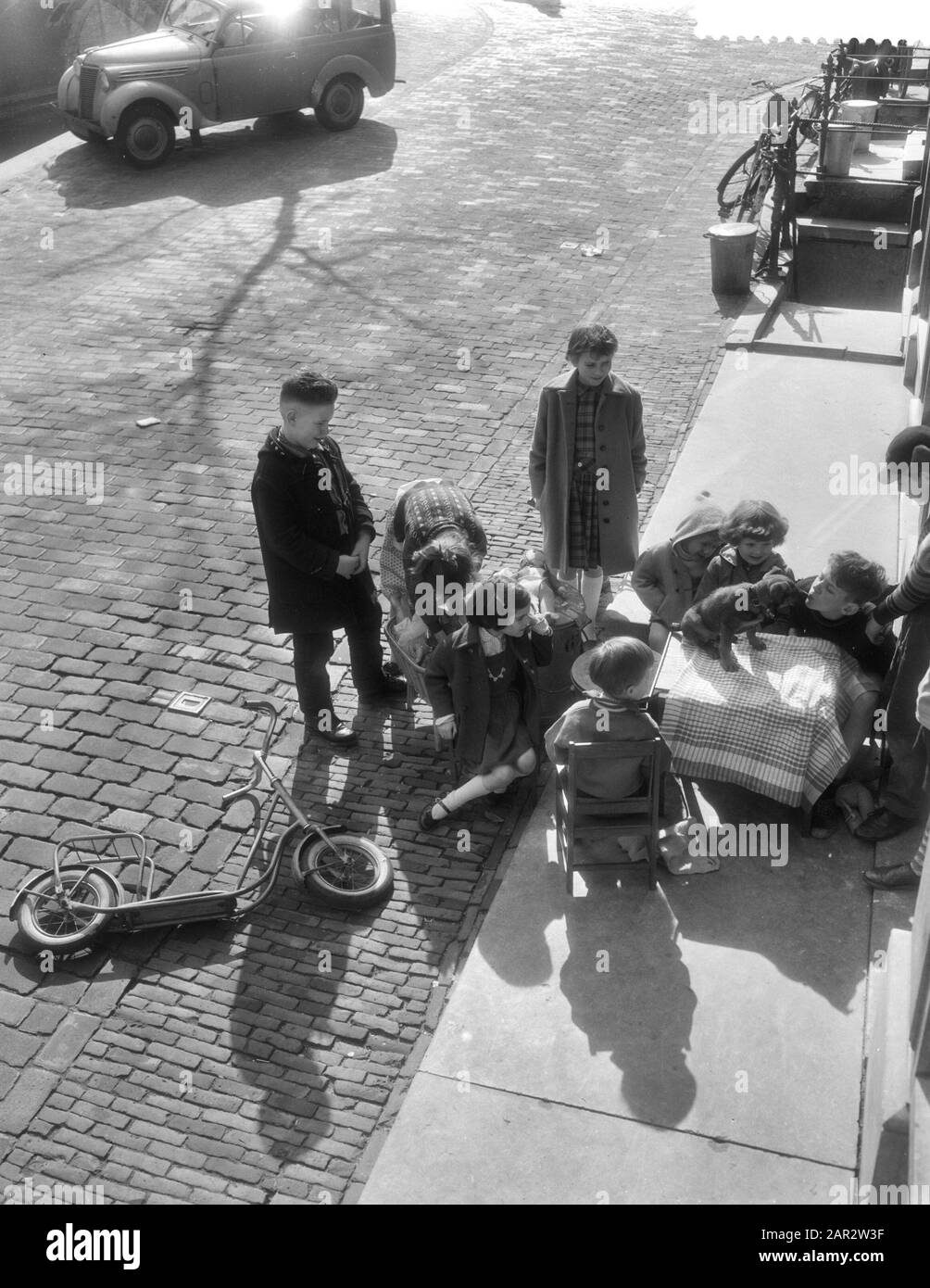 Bambini che giocano al sole durante le vacanze pasquali, sedie e tavoli fuori Data: 26 Marzo 1959 Parole Chiave: Bambini, GIOCARE, SOLE, sedie, tavoli Foto Stock