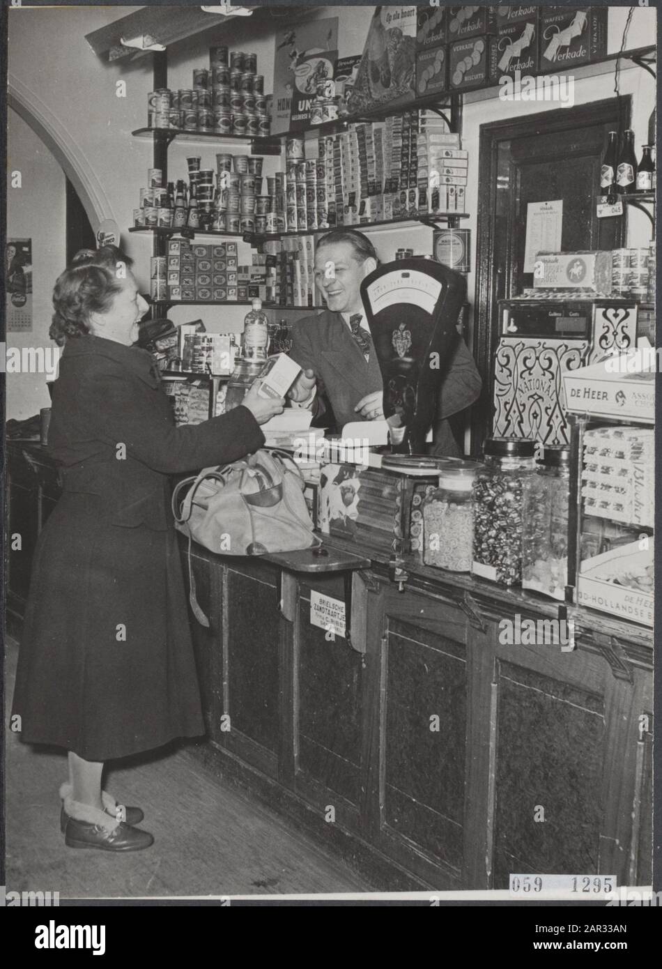 due colpi di luoghi colpiti dal diluvio 1953 e un anno dopo [due colpi di luoghi colpiti dal diluvio 1953 e un anno dopo]. Negozio di alimentari Don te Maassluis, 1 anno dopo l'alluvione Data: 28 Gennaio 1954 luogo: Maassluis Parole Chiave: Negozio alimentare, inondazioni, negozi Foto Stock