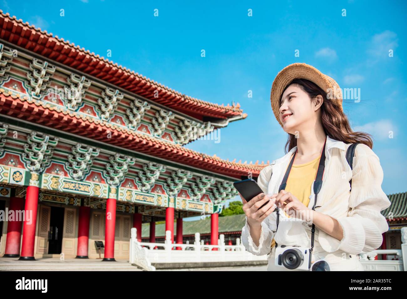 donna turistica con smartphone alla ricerca di informazioni di viaggio sul tempio Foto Stock