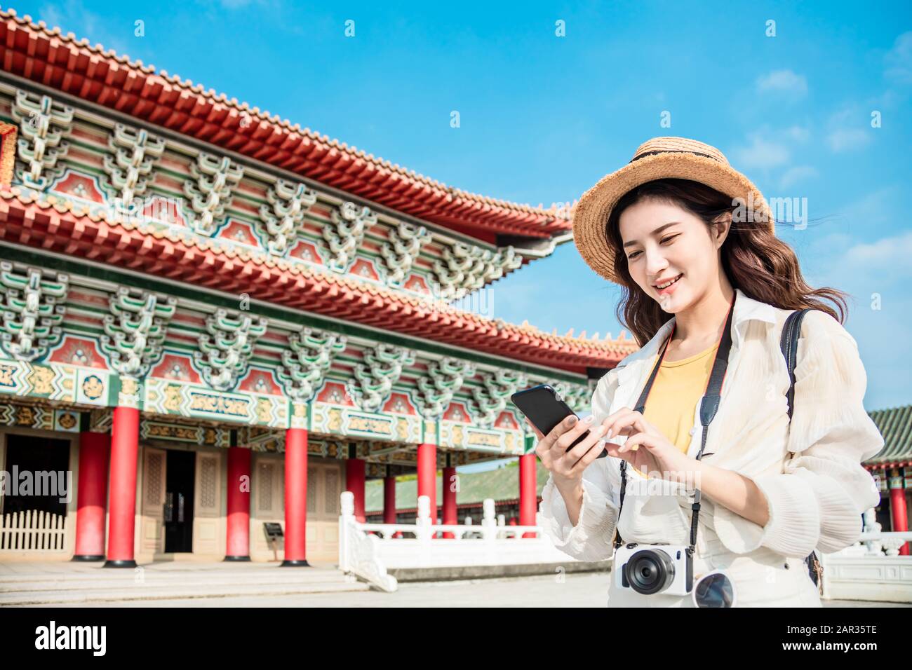 donna turistica con smartphone alla ricerca di informazioni di viaggio sul tempio Foto Stock