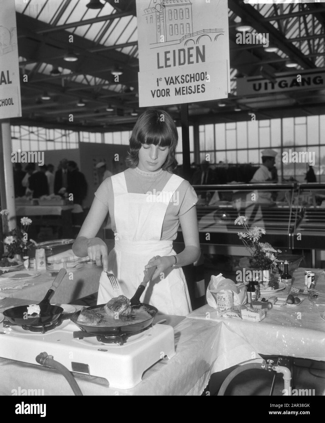 Scuola di famiglia 1965 studente della scuola di famiglia di Leiden mentre prepara un piatto di carne Data: 18 novembre 1965 Parole Chiave: Dimostrazioni, famiglie, cucina, ragazze, preparazione di cibo Foto Stock