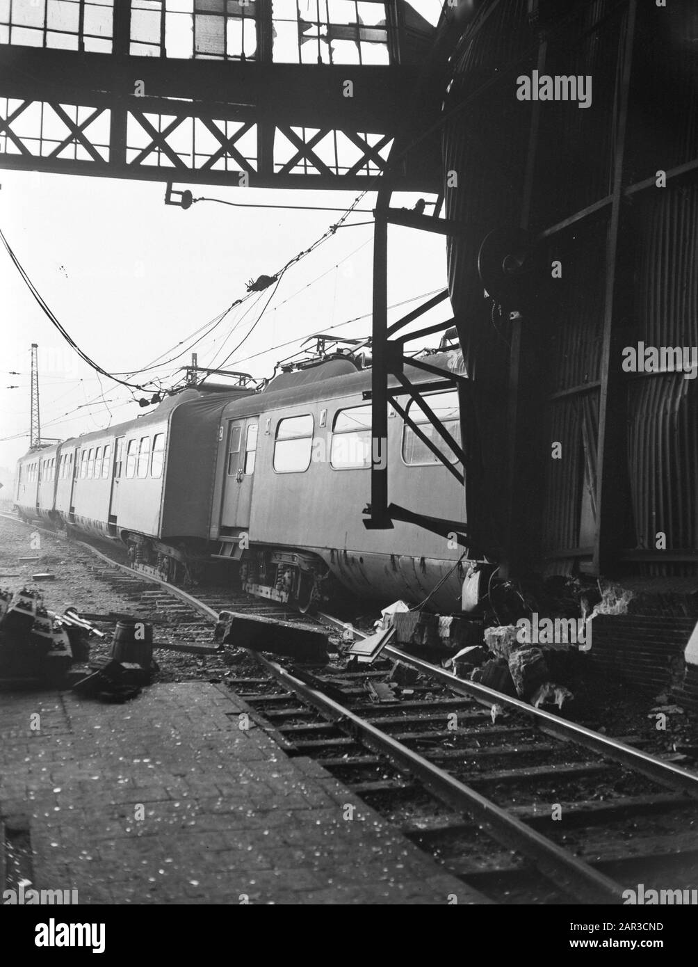 Un treno passeggeri alla stazione Hollands Spoor a l'Aia derailed mentre shunting e guidato nella tettoia della stazione. Nel treno non c'erano passeggeri Data: 20 dicembre 1955 Località: L'Aia, Zuid-Holland Parole Chiave: Incidenti ferroviari Foto Stock