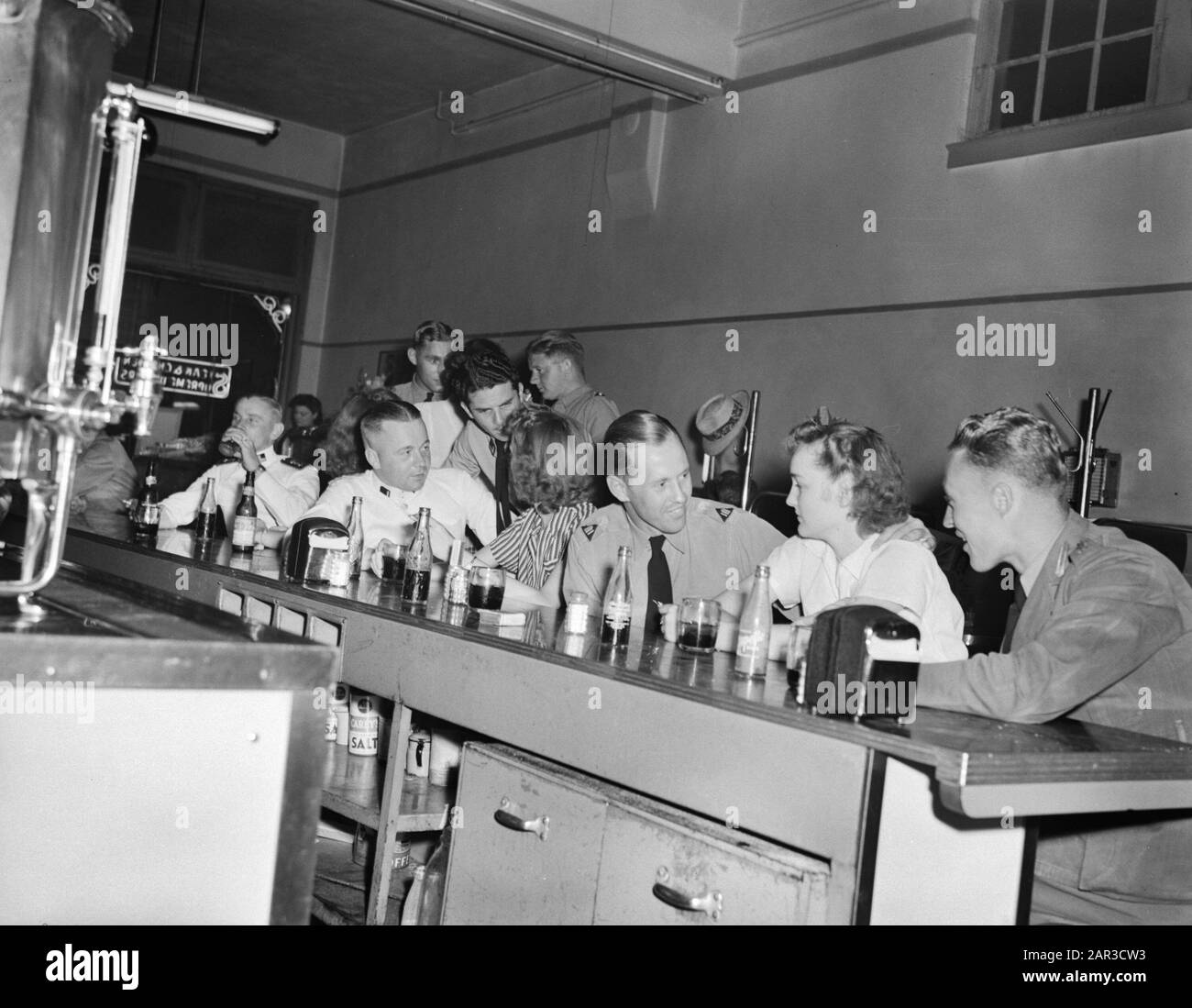 Royal Netherlands Scuola Militare Di Volo A Jackson, Mississippi. I piloti DELLA ML-KNIL, comandati Dal generale Maggiore L.H. van Oyen, fuggiti dalle Indie Orientali Olandesi, sono addestrati a Fort Jackson, Mississippi. Un gruppo di studenti olandesi e i loro amici americani si rilassano dopo l'orario di lavoro in una coca-cola in un negozio di droga in Jackson Annotation: 2nd uomo navale lasciato al bar è Adriaan Manschot - nato a Jaarsveld 1916, morto il 9 febbraio 1945 in una collisione tra due B25 Mitchells sopra Tienen (Tirlemont), Belgio. Fu poi ufficiale-Vlieger 2nd kl al 320 squadrone di RAF. Data: 16 Giugno, Foto Stock
