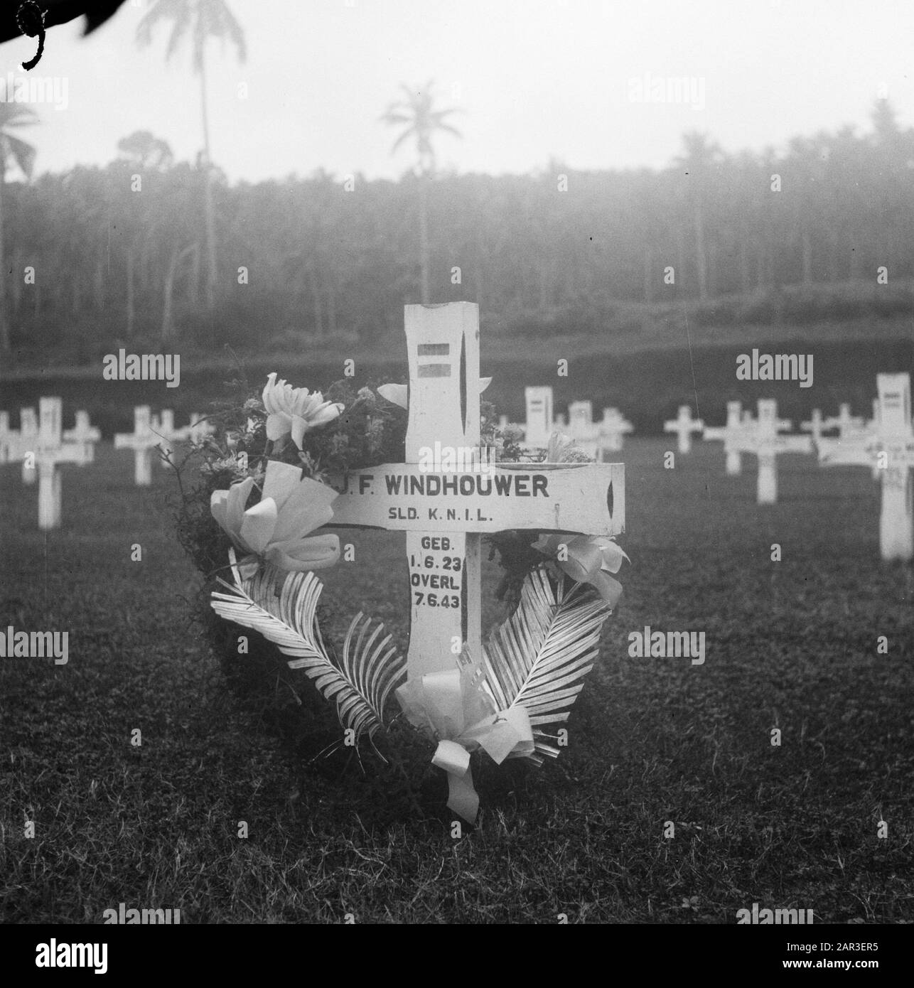 Cimitero Onorario Ambon. Croce sulla tomba di J.F. Windhouder, sld. INGINOCCHIATI. Nato 1-6-1923, Morto 7-6-1943 Annotazione: Joannes Ferdinand Windhoouwer. Nato Il 1° Giugno 1923 A Pagar Alam. Morto Il 7 Giugno 1943 A Kario/Haroekoe Data: 1947 Località: Ambon, Indonesia, Indie Orientali Olandesi Foto Stock