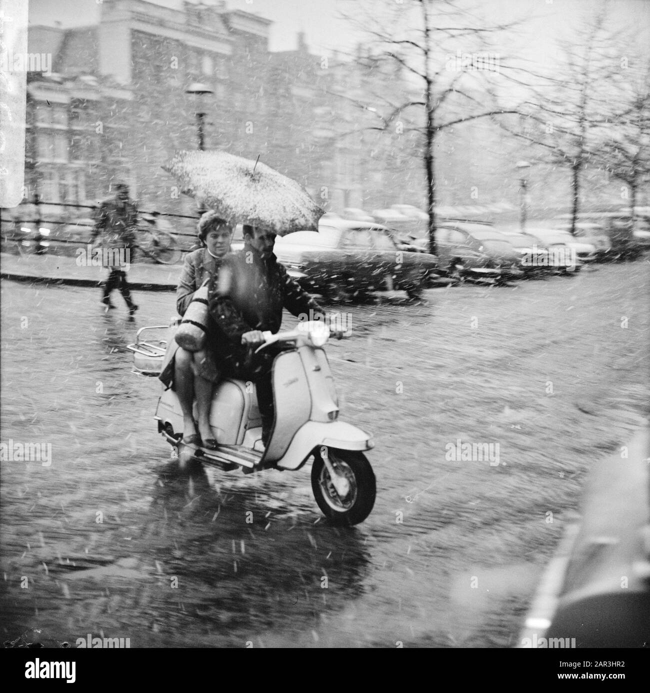 Snowshower, nel mese di marzo, persone sulla loro strada di casa (su scooter Data: 24 Marzo 1966 posizione: Amsterdam, Noord-Holland Parole Chiave: Snowshower, scooter Foto Stock