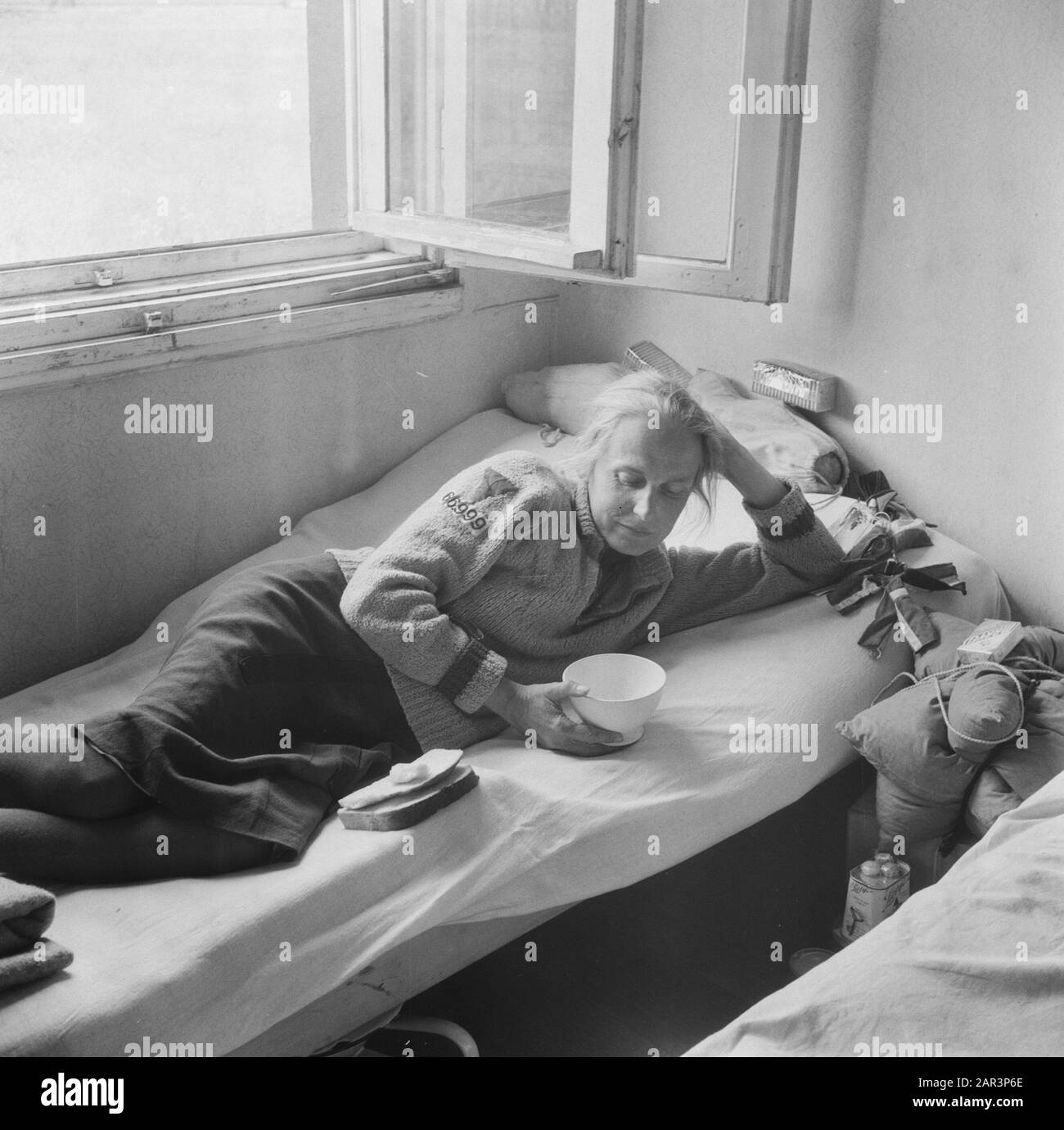 Rimpatrio Camp Rheine (Germania) [Renatriante si trova su un letto con nelle sue mani una ciotola e sul letto pezzi di pane] Annotazione: Sulla manica del suo gilet è un'etichetta con il numero 669999 cucito. Data: 1945 Luogo: Germania, Rheine Parole Chiave: Rimpatrio, Seconda Guerra Mondiale Foto Stock