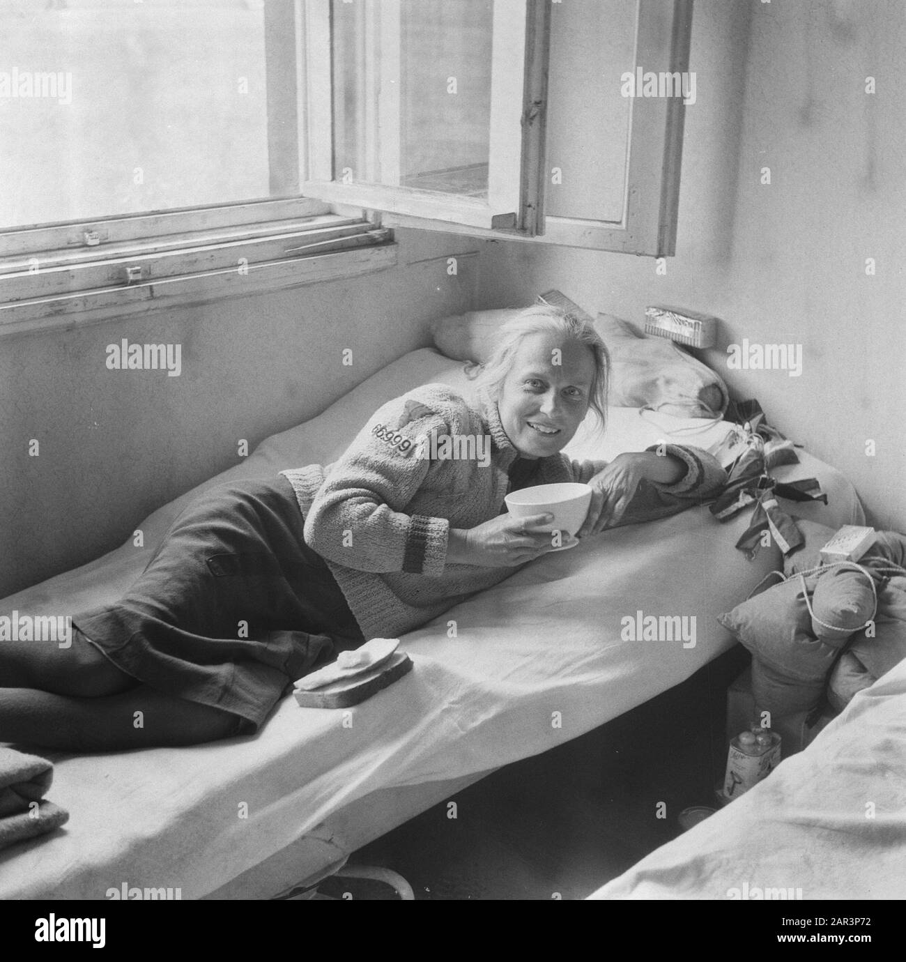 Rimpatrio Camp Rheine (Germania) [Renatriante si trova su un letto con nelle sue mani una ciotola e sul letto pezzi di pane] Annotazione: Sulla manica del suo gilet è un'etichetta con il numero 669999 cucito. Data: 1945 Luogo: Germania, Rheine Parole Chiave: Rimpatrio, Seconda Guerra Mondiale Foto Stock