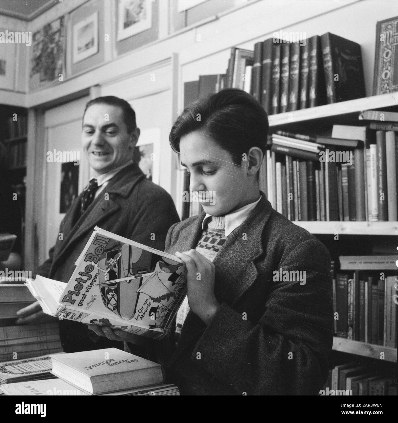 Finanza: Depurazione del denaro riduzione dei prezzi a seguito della ristrutturazione del denaro. Bookshop Annotazioni: Ragazzo Guarda il libro Pieje Bell andando a volare da Chris van Abkoude Data: 1945 Parole Chiave: Finanza, riduzioni di prezzo Foto Stock