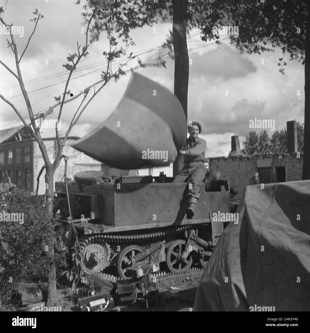 Devastazione. Militare alleato seduto su un vettore di bren che sventola una bandiera olandese Data: 14 febbraio 1946 Foto Stock