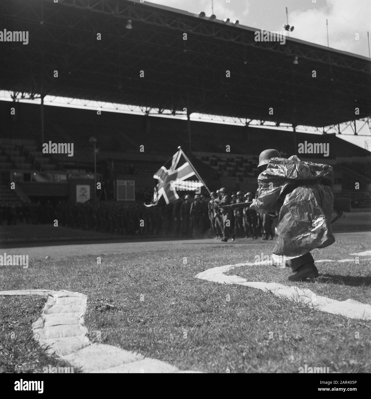 Prove generali per il gioco della Liberazione, che si terranno il 4 e 6 maggio 1946 alle prove generali dello Stadio Olimpico per il gioco della Liberazione, che si terranno il 4 e 6 maggio 1946 nello Stadio Olimpico di Amsterdam Annotazione: In primo piano un soldato tedesco. In background un gruppo guidato dalla bandiera britannica Data: 3 maggio 1946 luogo: Amsterdam Parole Chiave: Open air Theatre, prove Institution name: Olympic Stadium Foto Stock