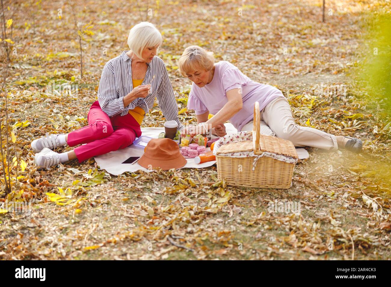 Amici alla scoperta del loro tavolo da picnic alla ricerca di frutta Foto Stock
